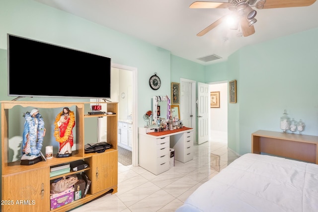 bedroom with connected bathroom, light tile patterned floors, and ceiling fan