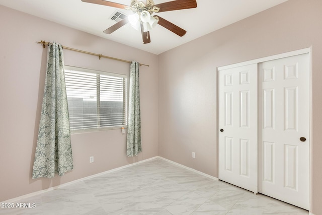 unfurnished bedroom with ceiling fan and a closet