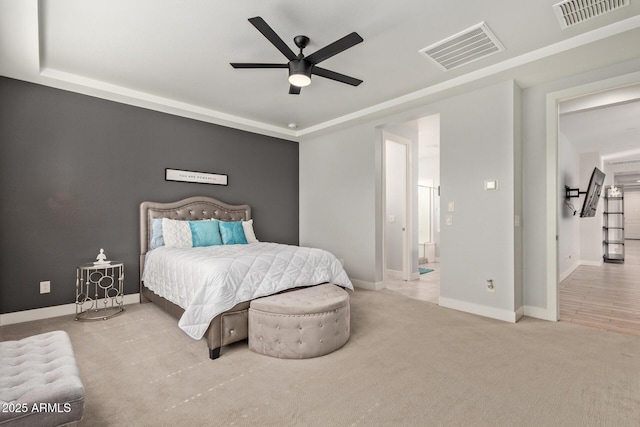 carpeted bedroom featuring a raised ceiling, visible vents, connected bathroom, and baseboards