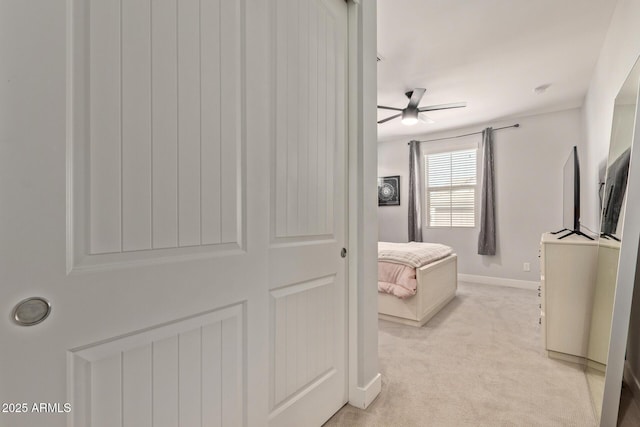 bedroom featuring light carpet and baseboards