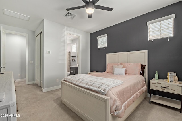 bedroom with light carpet, baseboards, visible vents, and connected bathroom