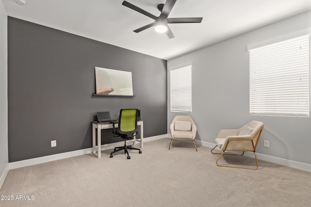 carpeted office with baseboards and a ceiling fan