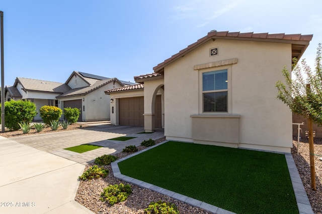 mediterranean / spanish home featuring a garage, decorative driveway, a tile roof, and stucco siding