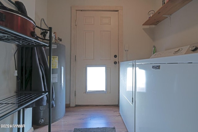 laundry area with light wood finished floors, washer and clothes dryer, and laundry area