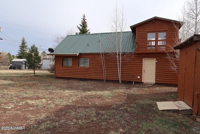 back of property featuring faux log siding and metal roof