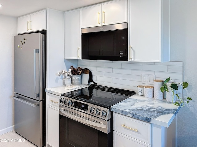 kitchen featuring stainless steel appliances, decorative backsplash, and white cabinets