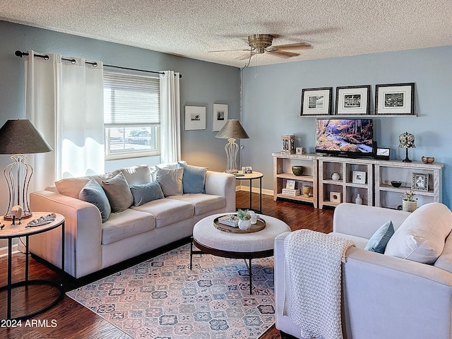 living room featuring ceiling fan, dark hardwood / wood-style floors, and a textured ceiling