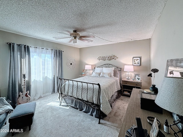 bedroom featuring ceiling fan, light colored carpet, and a textured ceiling