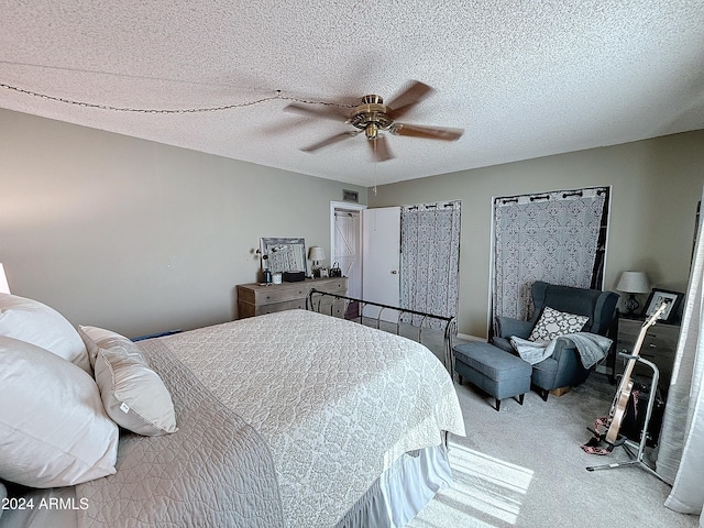 carpeted bedroom featuring ceiling fan and a textured ceiling