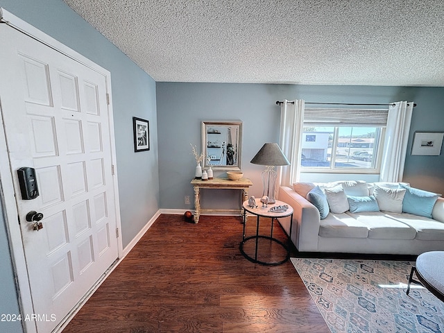 living room with dark wood-type flooring and a textured ceiling