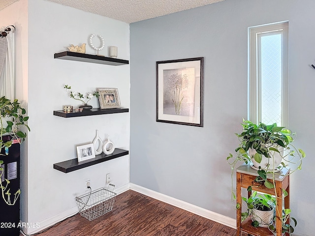 hallway featuring dark hardwood / wood-style floors and a textured ceiling