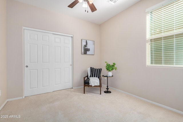 sitting room with visible vents, baseboards, a ceiling fan, and light colored carpet