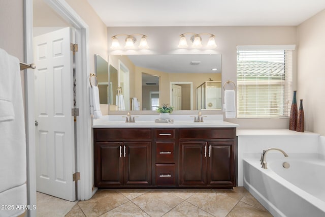 full bathroom with double vanity, a stall shower, a garden tub, and a sink