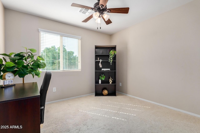 home office with a ceiling fan, light colored carpet, and baseboards