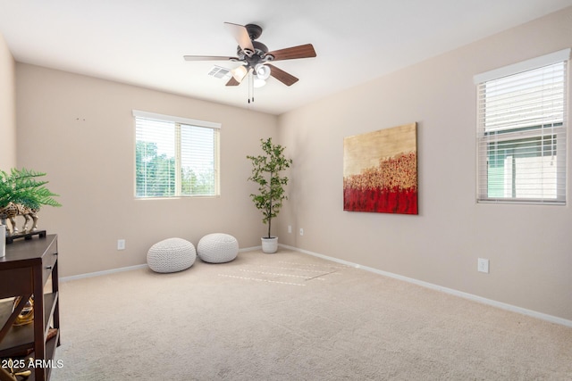 interior space with carpet, visible vents, ceiling fan, and baseboards