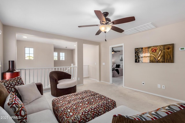 living area with light carpet, baseboards, and visible vents