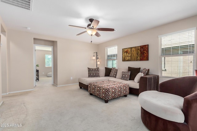 living area featuring light carpet, a ceiling fan, visible vents, and baseboards