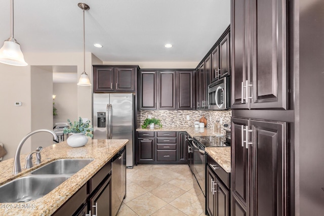 kitchen with stainless steel appliances, dark brown cabinets, a sink, and pendant lighting