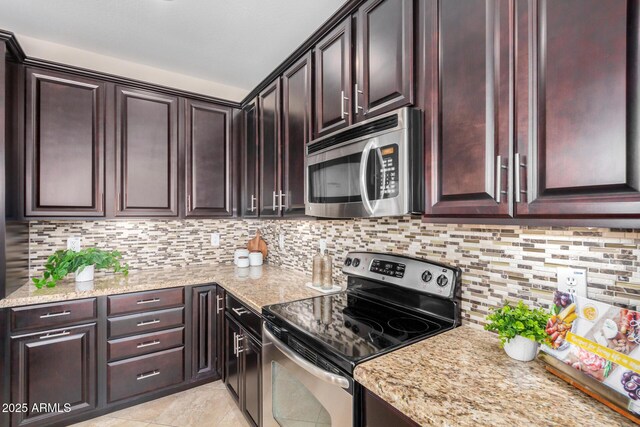 kitchen with light stone countertops, light tile patterned floors, stainless steel appliances, and decorative backsplash