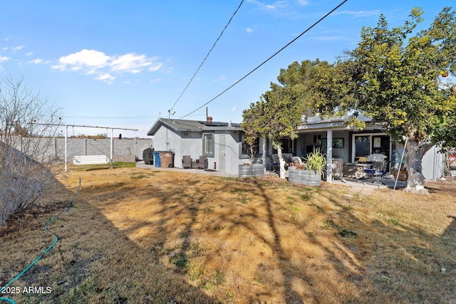 rear view of property featuring a yard and a patio