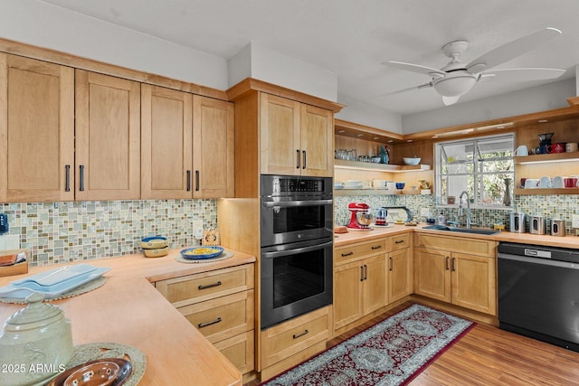 kitchen featuring sink, light hardwood / wood-style flooring, black dishwasher, double oven, and backsplash