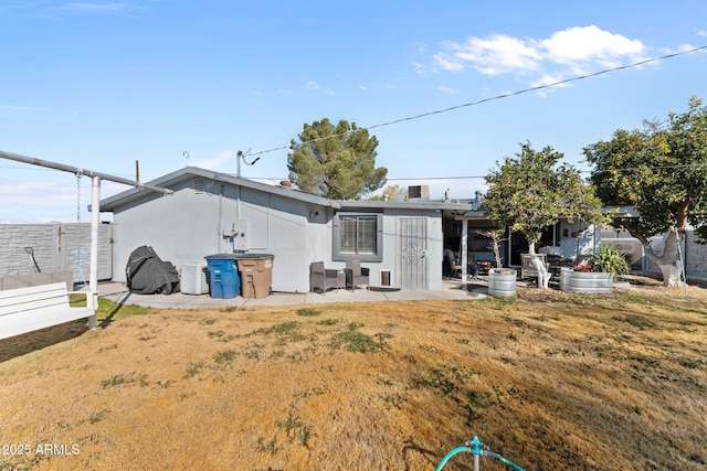 back of property with a yard and a patio