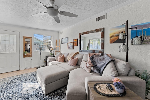 living room with ceiling fan, crown molding, tile patterned floors, and a textured ceiling