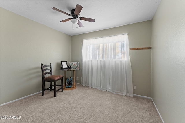 carpeted office space featuring ceiling fan