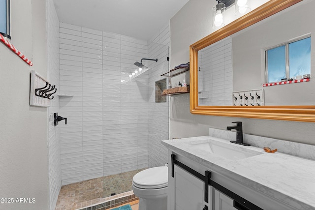 bathroom featuring vanity, toilet, and a tile shower