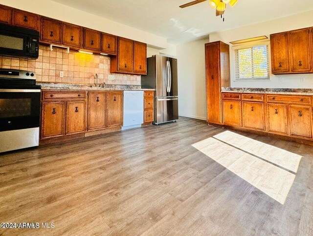 interior space featuring ceiling fan, a wall unit AC, and hardwood / wood-style flooring