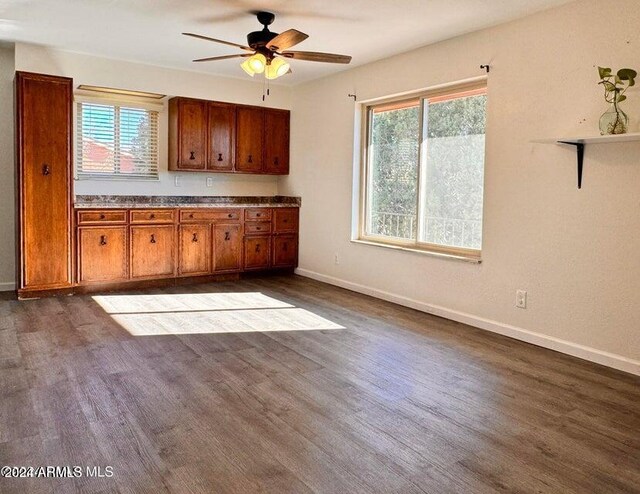 home office with ceiling fan, a wall mounted air conditioner, and dark hardwood / wood-style flooring