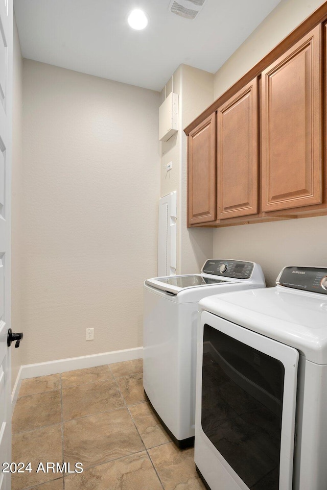 washroom featuring cabinets and washing machine and clothes dryer