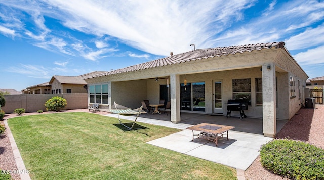 back of property featuring a lawn, a patio, and ceiling fan