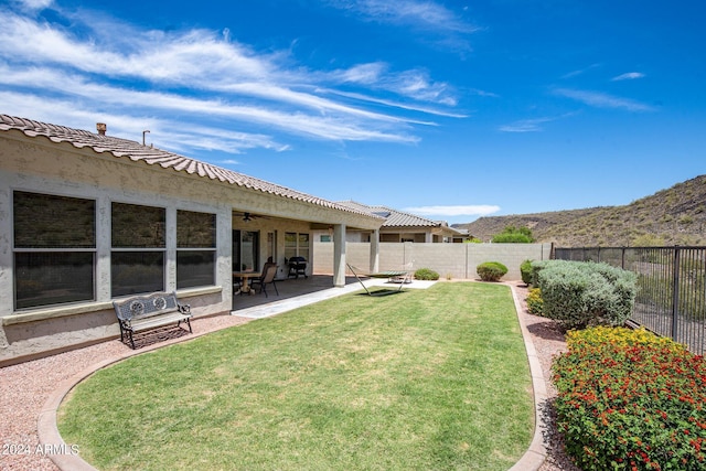 view of yard featuring a patio, a mountain view, and ceiling fan