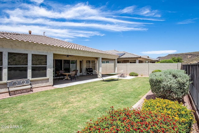 view of yard featuring ceiling fan and a patio