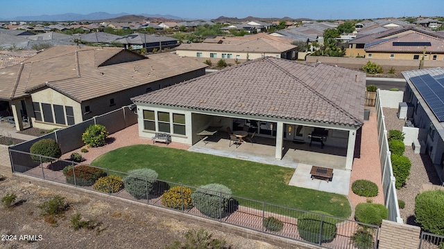 rear view of house featuring a yard, a mountain view, a patio area, and a fire pit