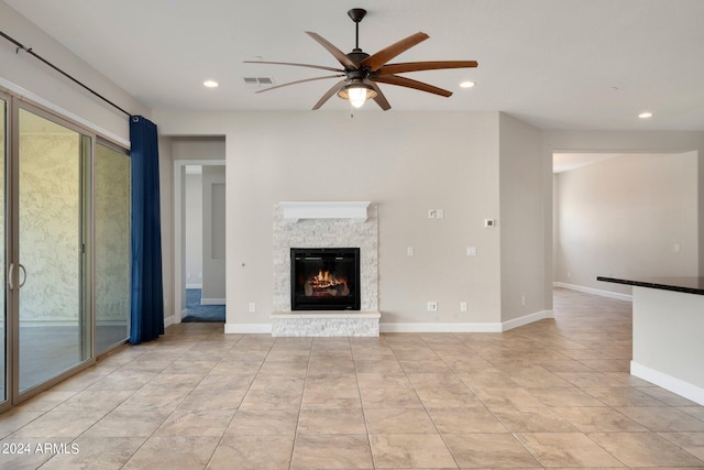 unfurnished living room featuring ceiling fan, a fireplace, and light tile patterned floors