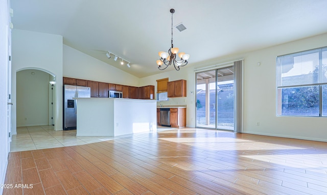 kitchen with pendant lighting, a center island, high vaulted ceiling, stainless steel appliances, and a chandelier