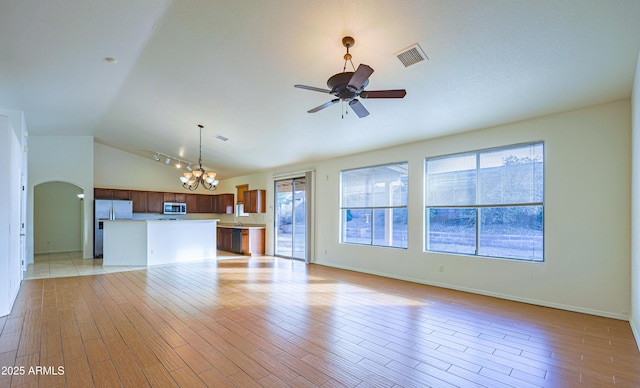 unfurnished living room featuring ceiling fan with notable chandelier, light wood-type flooring, and lofted ceiling