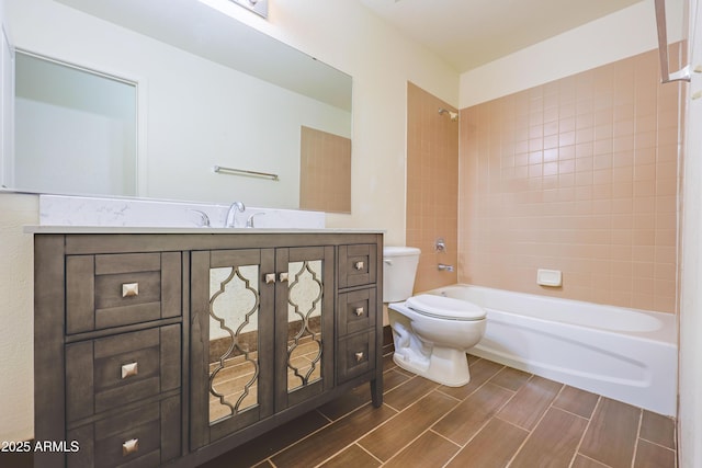 full bathroom with vanity, toilet, and tiled shower / bath