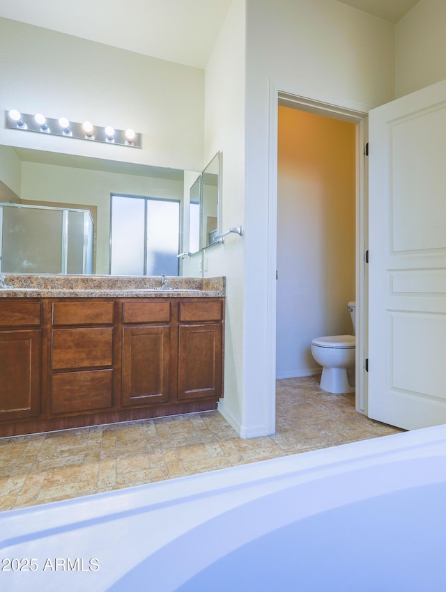 bathroom with vanity, toilet, and walk in shower