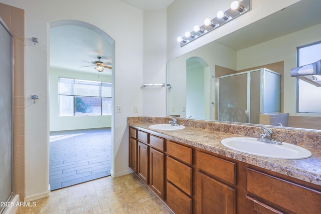 bathroom featuring ceiling fan, vanity, and a shower with shower door