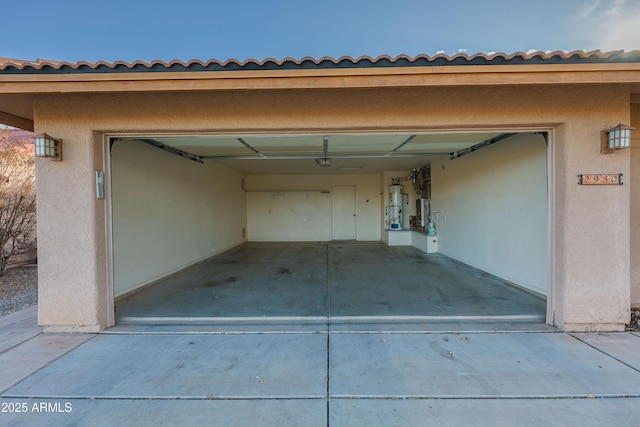 garage featuring a garage door opener and water heater