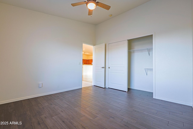 unfurnished bedroom featuring ceiling fan, dark wood-type flooring, and a closet