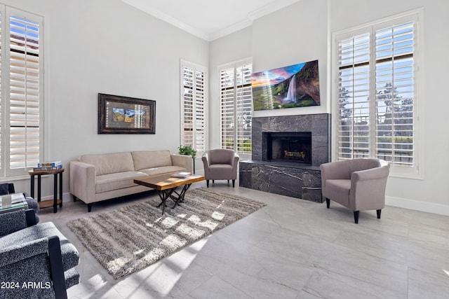 living room featuring a high end fireplace, crown molding, and a healthy amount of sunlight