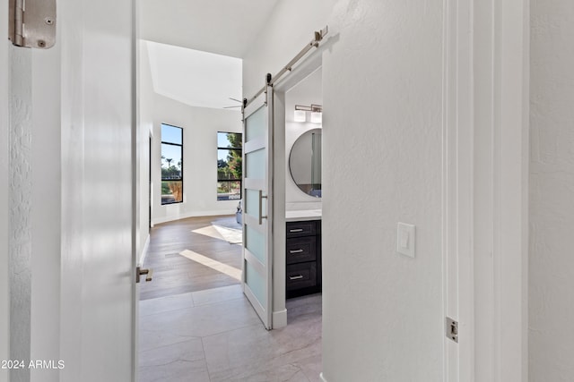 hallway featuring a barn door and light wood-type flooring