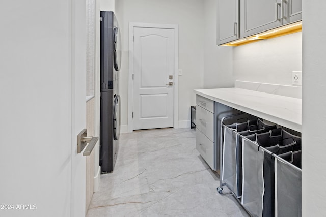 kitchen with gray cabinets and stacked washer / dryer