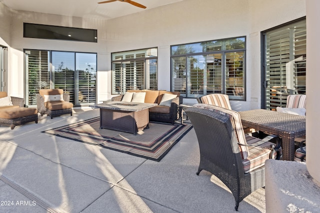 view of patio / terrace with ceiling fan and an outdoor living space with a fire pit