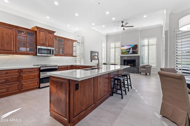 kitchen with a breakfast bar area, appliances with stainless steel finishes, backsplash, crown molding, and sink