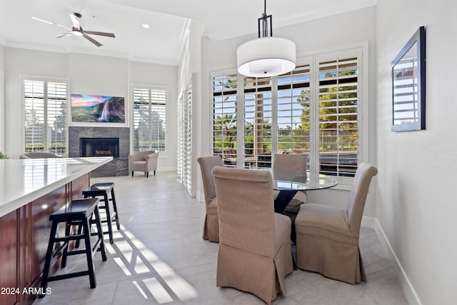 dining room with ornamental molding, a healthy amount of sunlight, ceiling fan, and light tile patterned floors